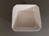 a white square bowl sitting on top of a table