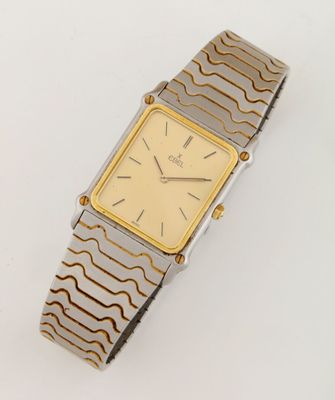 an image of a gold and silver wrist watch on a white surface