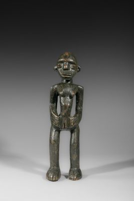 une petite figurine en bronze représentant un homme coiffé d'un chapeau