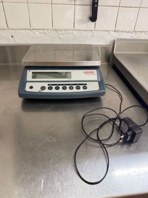 une photo d'une balance numérique posée sur un plan de travail de cuisine