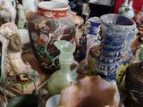 de nombreux vases posés sur la table dans la pièce