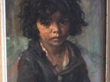 portrait of a young boy in a black coat by a wooden frame