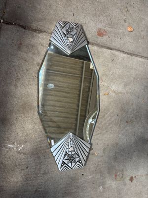un miroir posé sur le trottoir dans lequel se reflète une personne