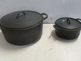 deux casseroles noires posées sur une table, sur fond blanc