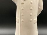 statue d'un homme vêtu d'une blouse blanche et d'un chapeau, la main levée