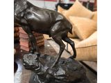 bronze statue of a deer on a rock in a living room