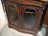 une armoire en bois avec un plateau en marbre et une porte vitrée