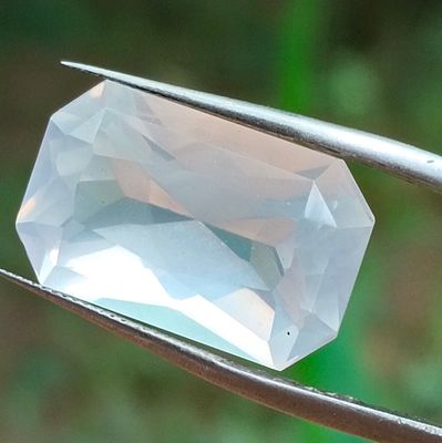 un diamant blanc maintenu par une paire de pinces
