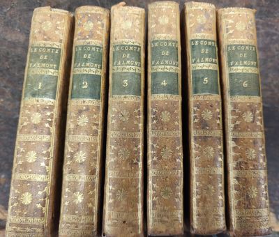 six vieux livres posés les uns à côté des autres sur une table