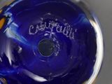 underside view of a blue glass vase with the word coutraince written on it