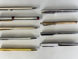 several different types of pens are lined up on a white surface