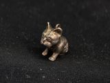 a small silver elephant figurine sitting on a black surface