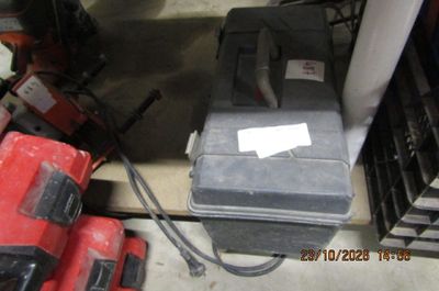 une photo d'une boîte à outils posée par terre à côté d'autres outils