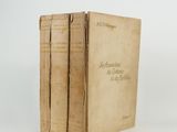 two old books sitting on top of each other on a white surface
