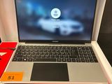 une personne est assise devant un ordinateur portable posé sur un bureau