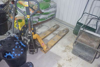 un tas d'ordures dans un garage, à côté d'une palette