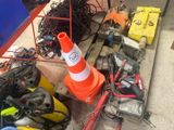un cône de signalisation posé par terre à côté d'un tas de fils électriques
