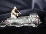 une figurine représentant un homme assis au bord d'un lit
