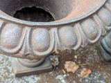 an old urn sitting on the ground next to a pair of boots