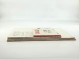 two books are stacked on top of each other on a white surface