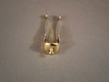 a small gold object on a table with a white background