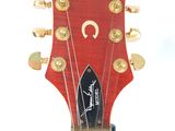 a close up of a red guitar with a black fretsch