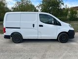 a white van parked in a parking lot with trees in the background