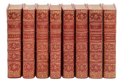 six livres rouges alignés sur une surface blanche