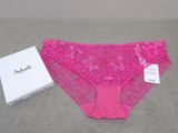 the pink panties are next to a white box on the bed