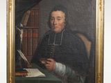 portrait of a man in a black robe holding a book and writing