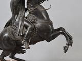 a statue of a man riding a horse on a wooden base