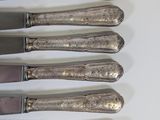 six knives are lined up in a row on a white surface