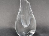 un vase en verre transparent posé sur une surface noire