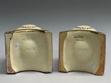 pair of gold and white porcelain vases with a bird on the top