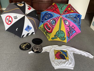 de nombreux parapluies de toutes sortes posés par terre