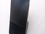 a black cell phone sitting on top of a stand