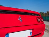 a red ferrari parked on the side of the road