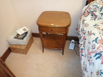 une petite table sur laquelle est posé un livre, à côté d'un lit