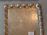 two silver trays sitting on top of a table next to each other