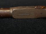 a close up of a pipe with a wooden handle on a black surface
