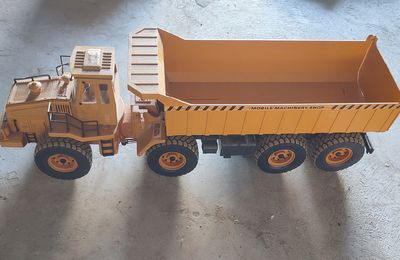 un camion miniature posé à côté d'un camion-benne miniature
