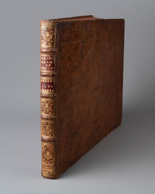 un vieux livre à la couverture brune posé sur une table