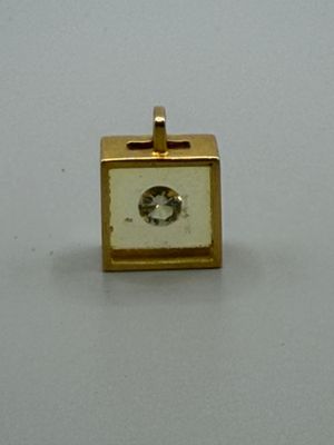 une petite horloge dorée posée sur une surface blanche