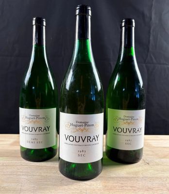 trois bouteilles de vin posées sur une table en bois