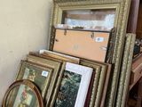 a lot of framed pictures on a shelf in a room