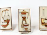 four pieces of glass with different designs on them on a white surface