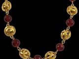 un collier en or orné de perles de verre rouges et muni d'un fermoir en or