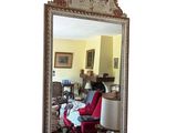 un miroir dans lequel se reflète un salon avec un fauteuil rouge