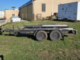 a trailer that is sitting in the grass in front of a building