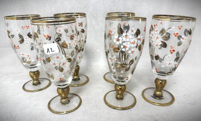 quatre verres à pied ornés d'une bordure dorée et de motifs floraux